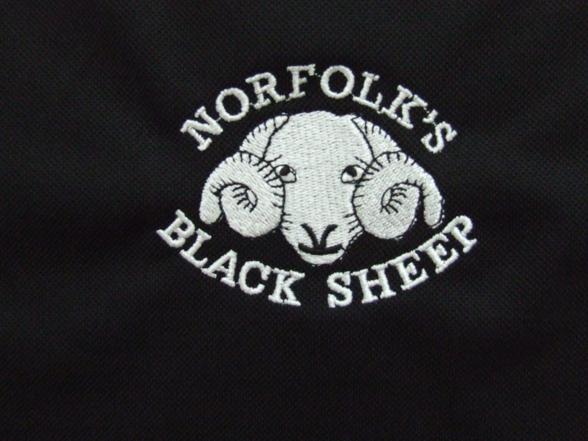 Detail of Black Sheep logo on polo shirt